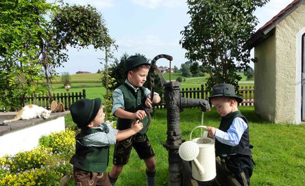Schwengelpumpe mit drei Jungs | © Tourist Info Bad Endorf