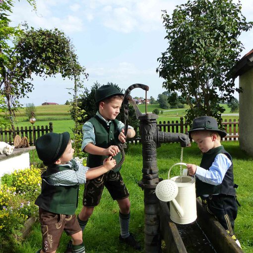 Schwengelpumpe mit drei Jungs | © Tourist Info Bad Endorf